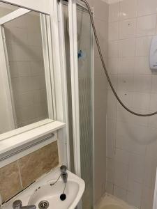 uma casa de banho com um lavatório e um chuveiro com um espelho. em Super Central Dublin Apartments em Dublin