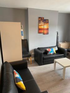 uma sala de estar com um sofá preto e uma mesa em Super Central Dublin Apartments em Dublin