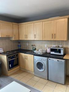 a kitchen with a washing machine and a microwave at Super Central Dublin Apartments in Dublin