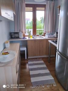 a kitchen with a stainless steel refrigerator and a sink at mieszkanie na wrzosowej in Kruklanki