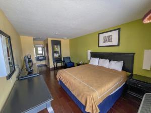 a hotel room with a bed and a flat screen tv at Deluxe Inn & Suites in Corpus Christi