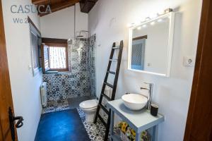 a bathroom with a sink and a toilet and a mirror at Casa rural Paraje de Yuste in Cuacos de Yuste