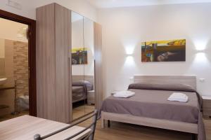 a bedroom with a bed and a mirror at Stella Marina - Camere e Monolocali Turistici in Monte San Biagio +26 photos