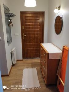 a bathroom with a wooden door and a rug at mieszkanie na wrzosowej in Kruklanki