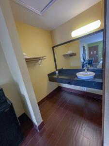 a bathroom with a sink and a large mirror at Deluxe Inn & Suites in Corpus Christi