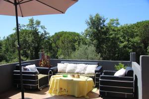 a patio with two couches and a table and an umbrella at Villa Elena Zagora in Neodi