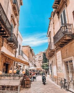 una calle en un casco antiguo con mesas y sillas en CasAlilò Casa Lecce Centro en Lecce