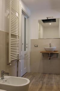 un bagno bianco con lavandino e specchio di Serendipity House a Grosseto