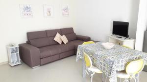 a living room with a couch and a table with yellow chairs at In Vacanza a Gaeta - Libera Stella in Gaeta