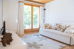a living room with a white couch and a window at Zwei Zimmer Ferienwohnung Rabiusa Churwalden in Churwalden