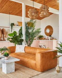 un sofá marrón en una sala de estar con plantas en The June Motel, en Sauble Beach