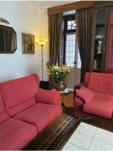 ein Wohnzimmer mit einem roten Sofa und 2 Stühlen in der Unterkunft Hotel Residencial Alentejana in Coimbra