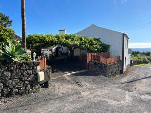 a house with a stone wall next to a street at Rosa do Canto in Monte