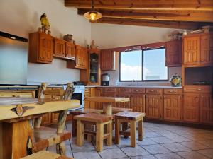 a kitchen with wooden cabinets and a table and benches at Hostal Pata de Perro in Creel