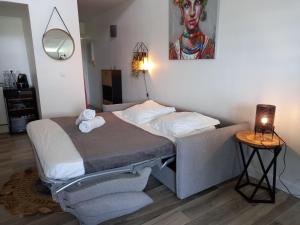 Cama pequeña en habitación con lámpara y mesa en casabeau village viva en Le Gosier