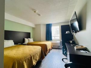 a hotel room with two beds and a television at Travelodge by Wyndham Brockville in Brockville