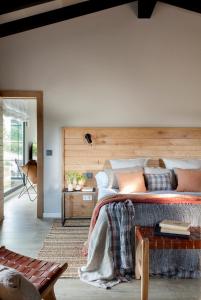 a bedroom with a large bed with a wooden headboard at La Guarida Lugás cabañas de lujo in Villaviciosa