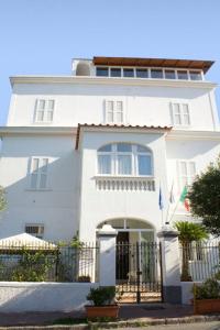 een wit huis met een hek ervoor bij Excelsior Mare Suite in Ischia