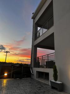 a sunset from the balcony of a building at Giannel Luxury Apartment 1 in Kastanéa