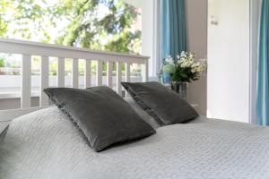 łóżko z dwiema poduszkami i oknem w obiekcie Apartament Anna w mieście Sopot