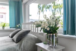 wazon kwiatów na stole w sypialni w obiekcie Apartament Anna w mieście Sopot