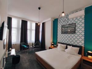 um quarto de hotel com uma cama branca e uma parede verde em B&B Dolac em Zagreb