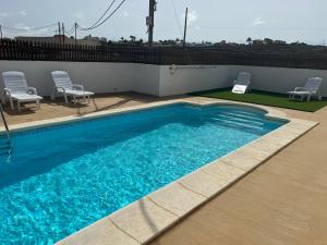 una grande piscina blu con due sedie di Casa Escanfraga I a Villaverde