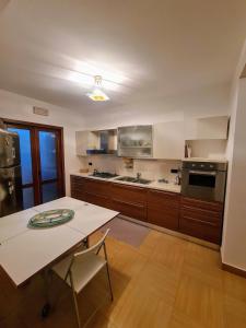a large kitchen with a white table and a counter at Diamante 46, Appartamento per vacanza in Diamante