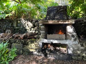 un four en pierre avec une cheminée à l'intérieur dans l'établissement Rosa do Canto, à Monte