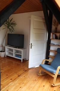 a living room with a door and a tv and a chair at Ferienwohnung Kanalblick in Schacht-Audorf