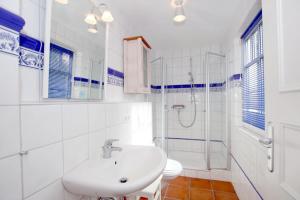 a white bathroom with a sink and a shower at Wiesenweg 4a, Whg 3 in Wyk auf Föhr