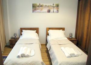 2 Betten in einem Zimmer mit weißer Bettwäsche und Handtüchern in der Unterkunft Family apartments in Tbilisi City