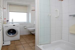ein Badezimmer mit einer Waschmaschine und einem WC in der Unterkunft Königstr.5, Whg. 33, Atlantischer Hof in Wyk auf Föhr