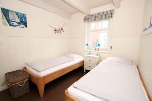 Duas camas num pequeno quarto com uma janela em Susanne-Fischer Weg 33, Haus Garnele em Wyk auf Föhr