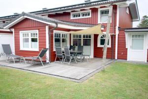 eine Terrasse mit Stühlen und einem Tisch vor einem Haus in der Unterkunft Susanne-Fischer Weg 45, Haus Taschenkrebs in Wyk auf Föhr