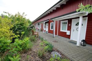 a red building with a bench next to it at Susanne-Fischer Weg 39, Haus Knurrhahn in Wyk auf Föhr