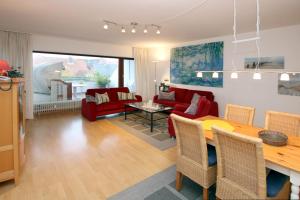 - un salon avec une table et un canapé rouge dans l'établissement Gro_e Stra_e 19_ Whg_ 3, à Wyk auf Föhr