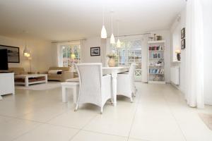 un comedor blanco con mesa y sillas en Ohl Doerp 55b_ Whg_ 2, en Wrixum