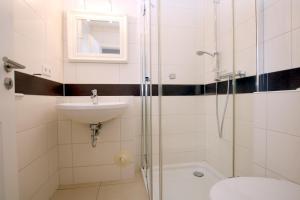 La salle de bains est pourvue d'une douche, d'un lavabo et de toilettes. dans l'établissement Ohl Doerp 55b_ Whg_ 2, à Wrixum