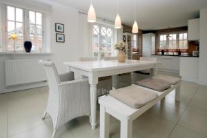 uma cozinha branca com uma mesa e cadeiras brancas em Ohl Doerp 55b_ Whg_ 2 em Wrixum