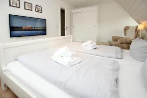 a white room with two white towels on a bed at Ohl Doerp 55b_ Whg_ 2 in Wrixum