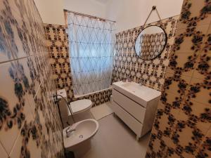 a bathroom with a sink and a toilet and a mirror at Reis Turismo 2 in Faro