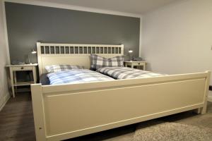 een slaapkamer met een wit bed met 2 kussens bij Luettmarsch 13_ Whg_ 1 in Wyk auf Föhr