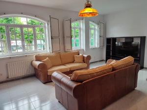 uma sala de estar com dois sofás e uma televisão em Alameda House em Santa Marta de Ortigueira