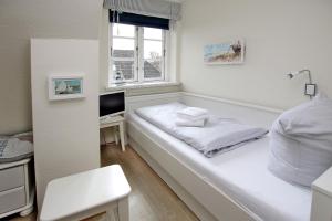 a white room with a bed and a window at Ohl Doerp 22 Pastoratshof_ Haus 3 in Wrixum