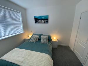 a bedroom with a bed and two lamps and a window at Modern 2 bedroom apartment, with car parking. in Bitton