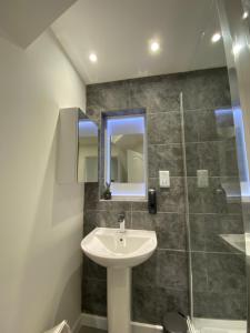 a bathroom with a sink and a shower at Modern 2 bedroom apartment, with car parking. in Bitton