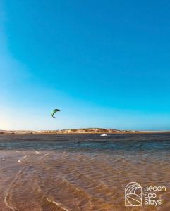 a person flying a kite over a body of water at Beach Eco Stays Hotel Boutique Lagoinha in Paraipaba