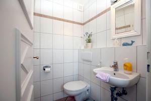 Baño blanco con aseo y lavamanos en Karkstieg 6_ Whg_ 1_ Vogtum, en Wrixum