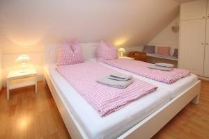 a bedroom with two beds with pink and white sheets at Karkstieg 6_ Whg_ 1_ Vogtum in Wrixum